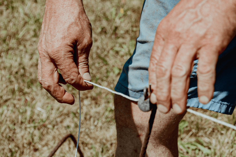 Hand spannt einen Weidezaun
